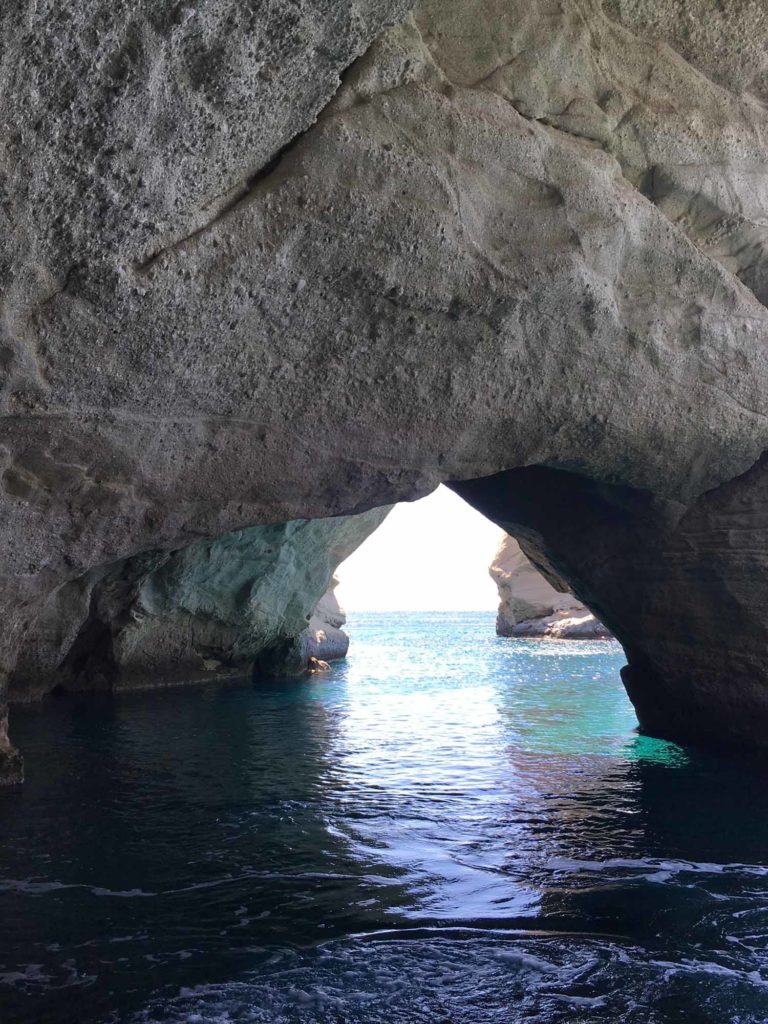 rocks forming an arch with ocean water beneath
